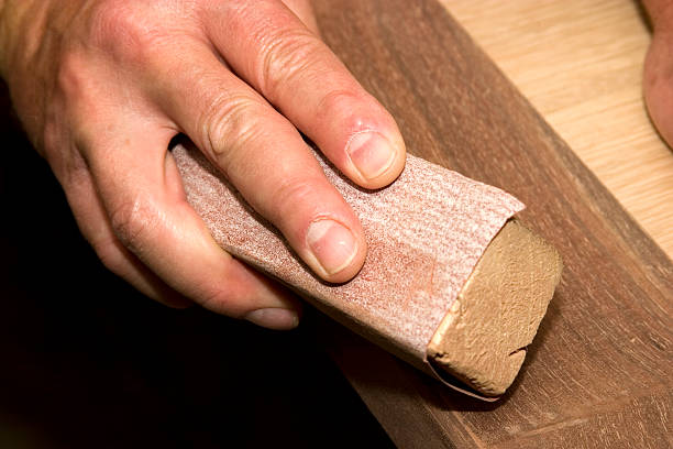 Close-up of a man sanding by hand in the workshop stock photo