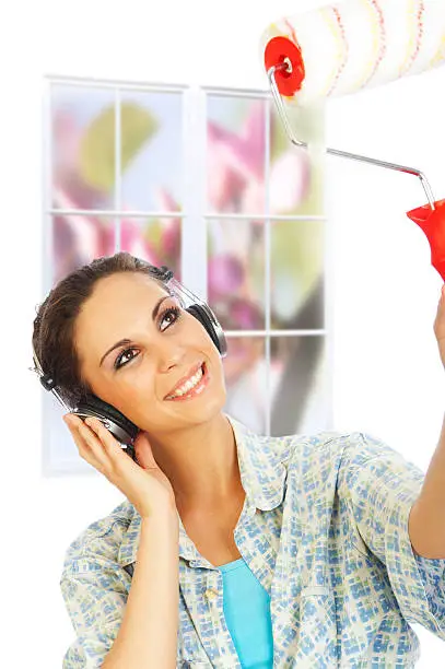 Closeup of young attractive woman enjoy listen music and painting her house