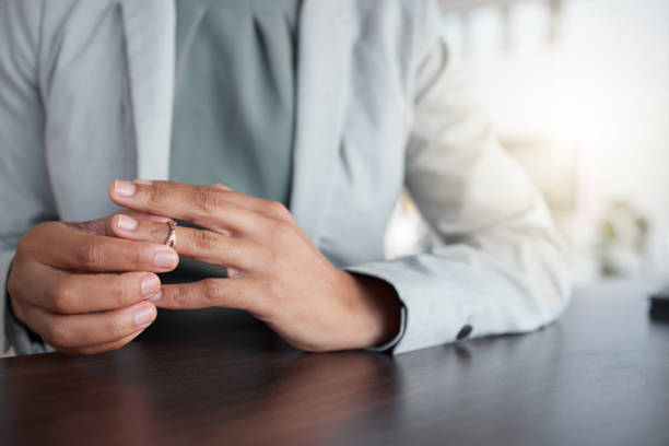 hand oder finger, ring und scheidung einer frau am tisch mit zweifeln, angst oder dem nachdenken über depressionen. weibliche person, die eheringschmuck für trennungsberatung, betrug oder fehler abnimmt - jacob wackerhausen stock-fotos und bilder