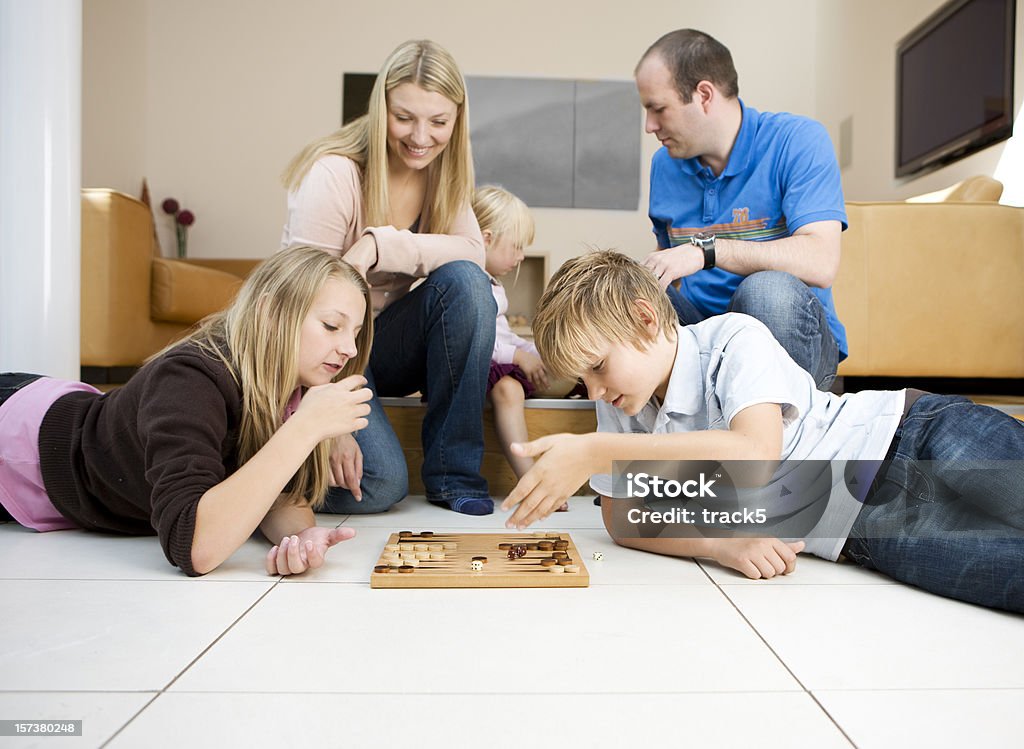 Joven familia relajarse juntos en su casa jugando videojuegos - Foto de stock de Familia libre de derechos
