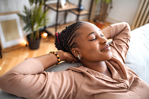 Black woman relaxing on her living room sofa