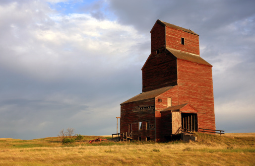 An old grain elevator on the prairie. Old wooden grain elevators - such as this one located near Saskatoon, Saskatchewan - are disappearing fast. They reflect a simpler time on the great plains when small farms and the agriculture industry was more of a grassroots, everyman way of life. This beautiful grain elevator is one of just a couple of hundred left in the province of Saskatchewan, which has one of the largest collections of historic grain elevators in the world. 