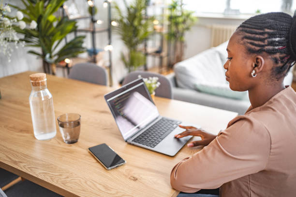 istock Black woman programming on her laptop at home 1573805350