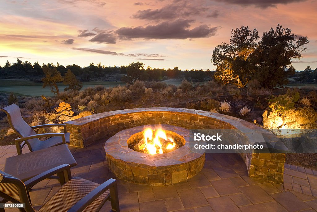 Stone Fire Pit stone fire pit with outdoor chairs, enjoying the sunset and landscape. Fire Pit Stock Photo