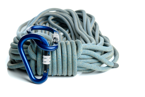 Tied ropes in a knot in the middle on a blue sailcloth, close-up. A nautical knot made of ropes on canvas.