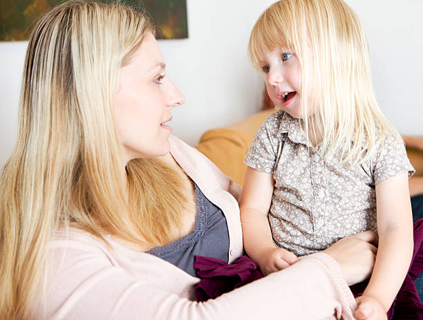 Mother and daughter candidly bonding together at home stock photo