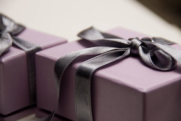 Lavender gift box with a dark purple satin bow stock photo