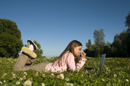 little girl is playing game in laptop