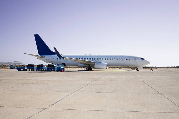 Airplane loading on airport Cargo containers by side profile of an airplane on tarmac. airfield stock pictures, royalty-free photos & images