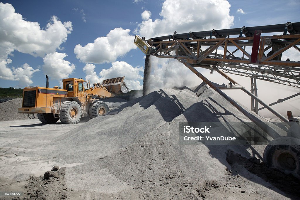 Functioning industrial quarry with trucks at work tractor loading in quarry Conveyor Belt Stock Photo