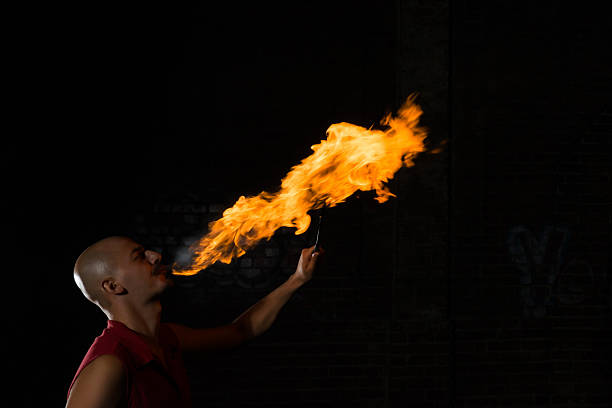 istock Street Performer Fire Breather Blowing on Torch 157381805