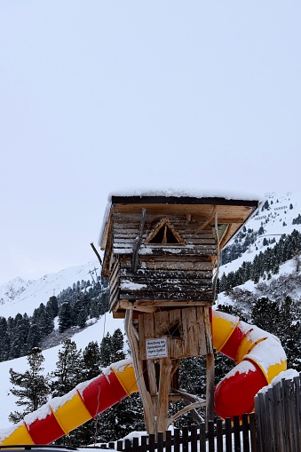 Snowy slide and climbing frame in ski resort's children's playground