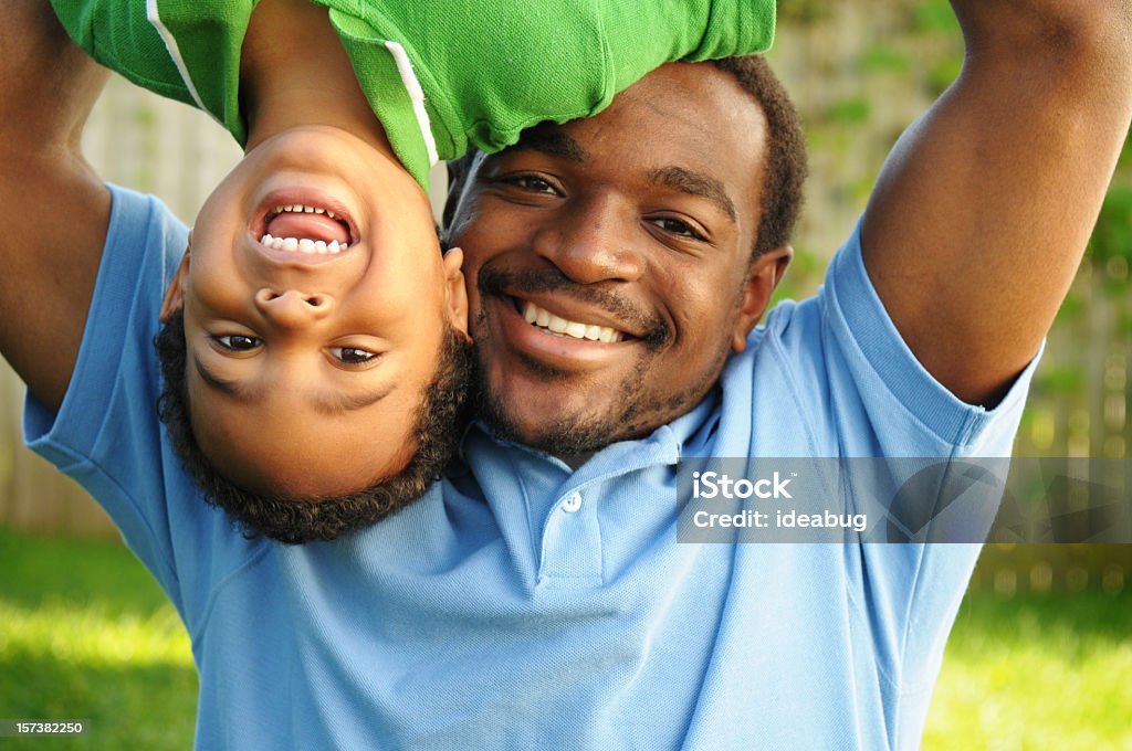 Afro-americane padre giocando con suo figlio fortuna - Foto stock royalty-free di Capovolto