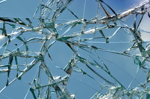 Thick broken glass of a window in an abandoned industrial zone.