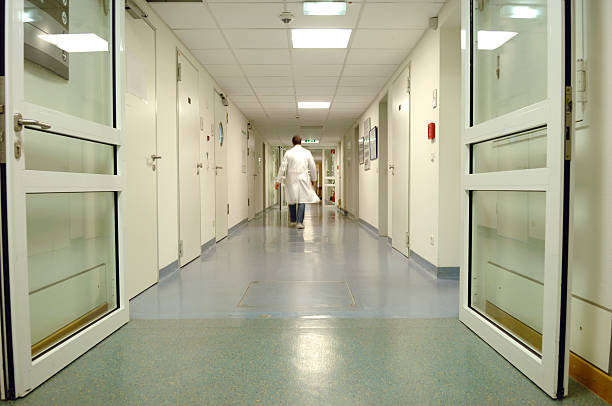 Doctor walking through a hospital corridor stock photo