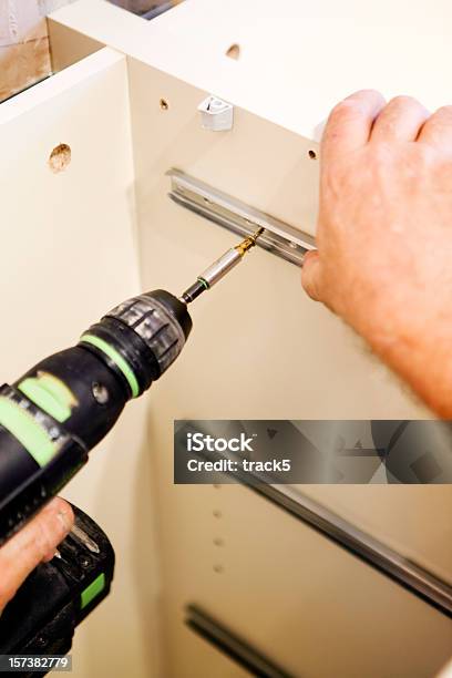 Kitchen Fitters Fitting Drawer Runners Using An Electric Screwdriver Stock Photo - Download Image Now