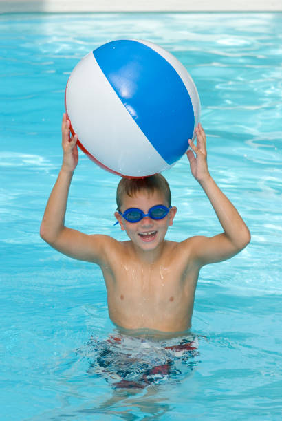 istock Happy Young Boy In Swimming Pool With A Beach Ball 157382819