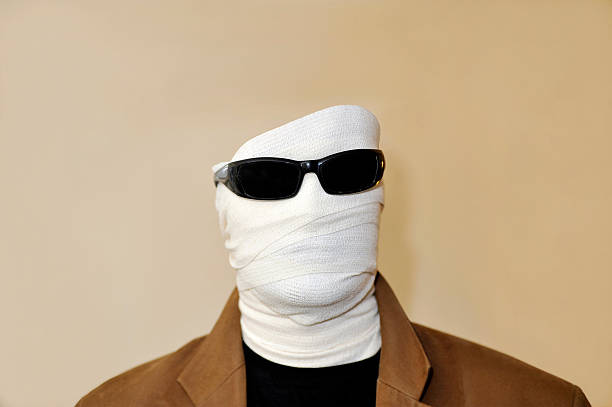 Invisible man with white bandaged face and sunglasses stock photo