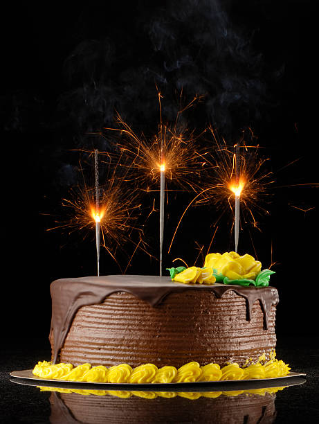 Chocolate birthday cake with sparklers on a black background