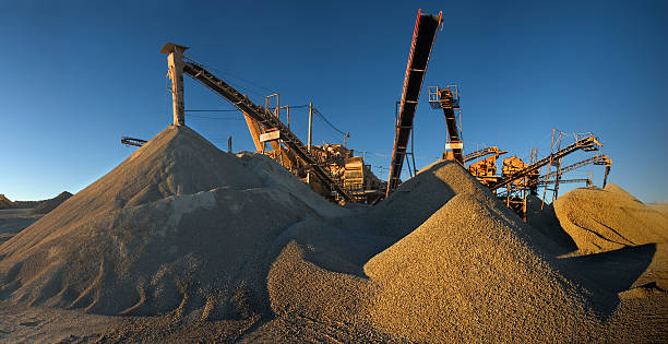 Machinery, gravel and sand II Panoramic image of a gravel mine before sunset. Big machinery and a lot of sand and gravel. sand mine stock pictures, royalty-free photos & images