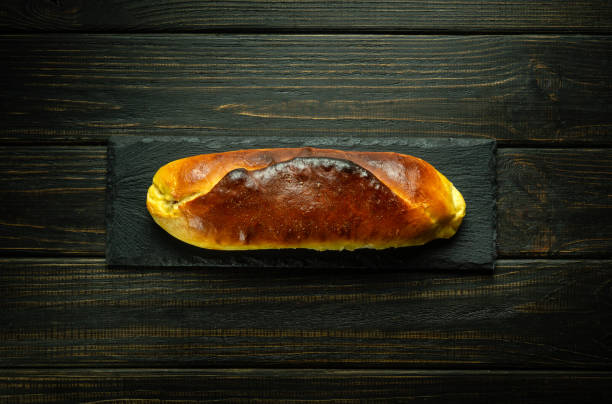 istock Appetizing baked pie on a black sorting board. Culinary pastry concept for hotel or restaurant on dark background 1573831490