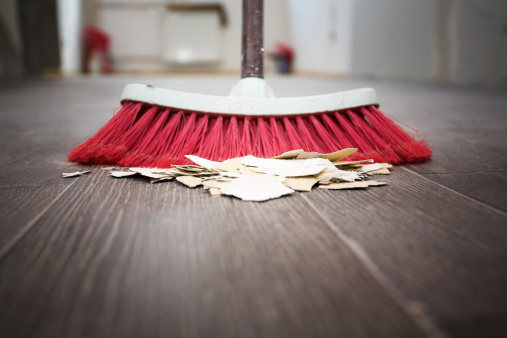 Sweeping the floor with a broom - cleaning house.