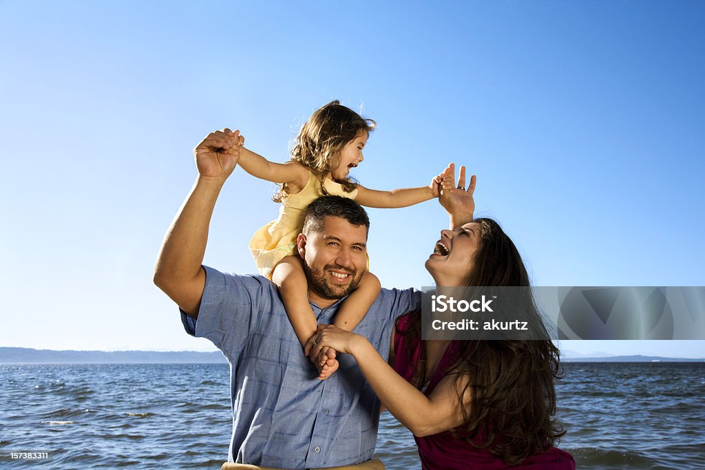 ハッピーヒスパニックご家族でのバケーションの娘笑うオーシャンビーチ - 2歳から3歳のロイヤリティフリーストックフォト