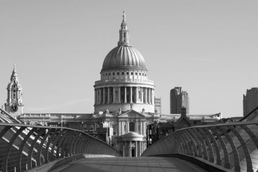 Millennium Bridge, leading to the Cathedral, on a sunny morning in London. Black and white view from Tate Modern.
