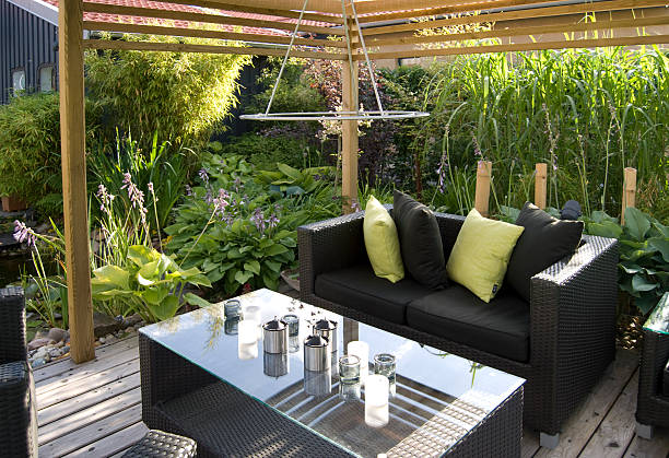 Patio with an outdoor wicker sofa and table Modern outdoor living, with wicker sofas and table. garden lights candle stock pictures, royalty-free photos & images