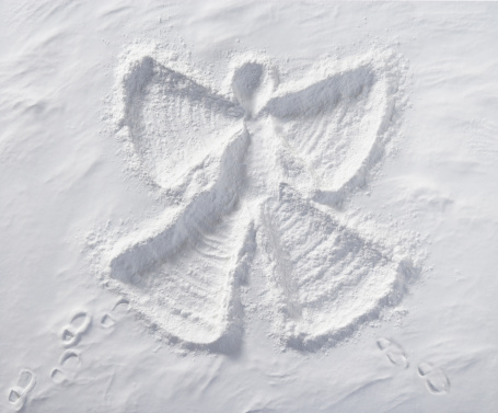 Snow Angel with foot prints in snow. Photographed from directly above.