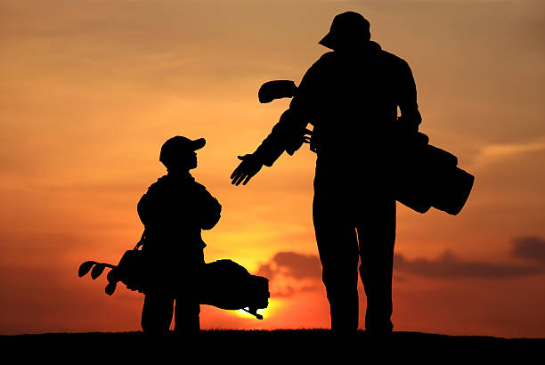 силуэт отец и сын на поле для гольфа - child family tutor father стоковые фото и изображения