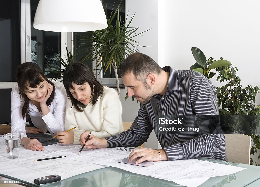 Architects meeting Architect and clients having fun, looking over some blueprints, in a meeting Architect Stock Photo