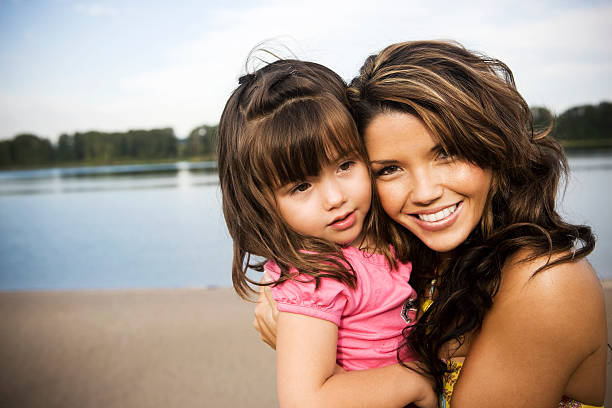 Mother sincerely hugging her child during vacation with copy space.