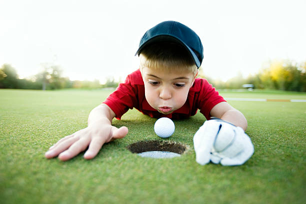 получите в отверстие! - golf child sport humor стоковые фото и изображения