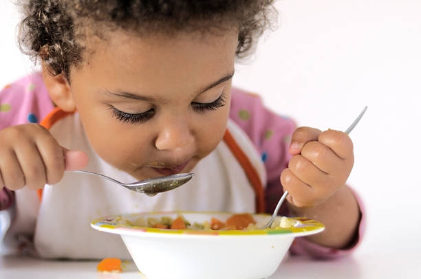 istock A young girl eating from a bowl 157383635