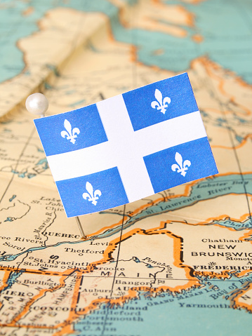 Quebec flag over more that sixty years old map pointing Quebec city. Shallow depth of field