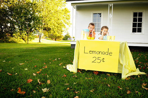 aborrecido rapaz e rapariga pé atrás da barraca de venda de limonada - lemonade stand lemonade child failure imagens e fotografias de stock