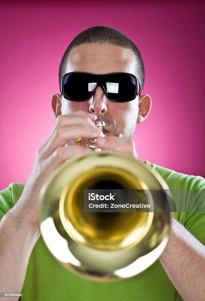 trumpet mężczyzna Muzyk gra na różowym tle - Zbiór zdjęć royalty-free (Trąbka)