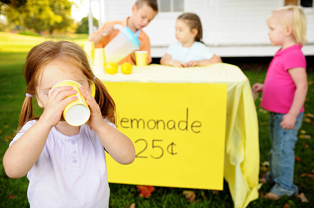 ragazzina beve limonata davanti a una posizione - lemonade stand lemonade waiting in line child foto e immagini stock