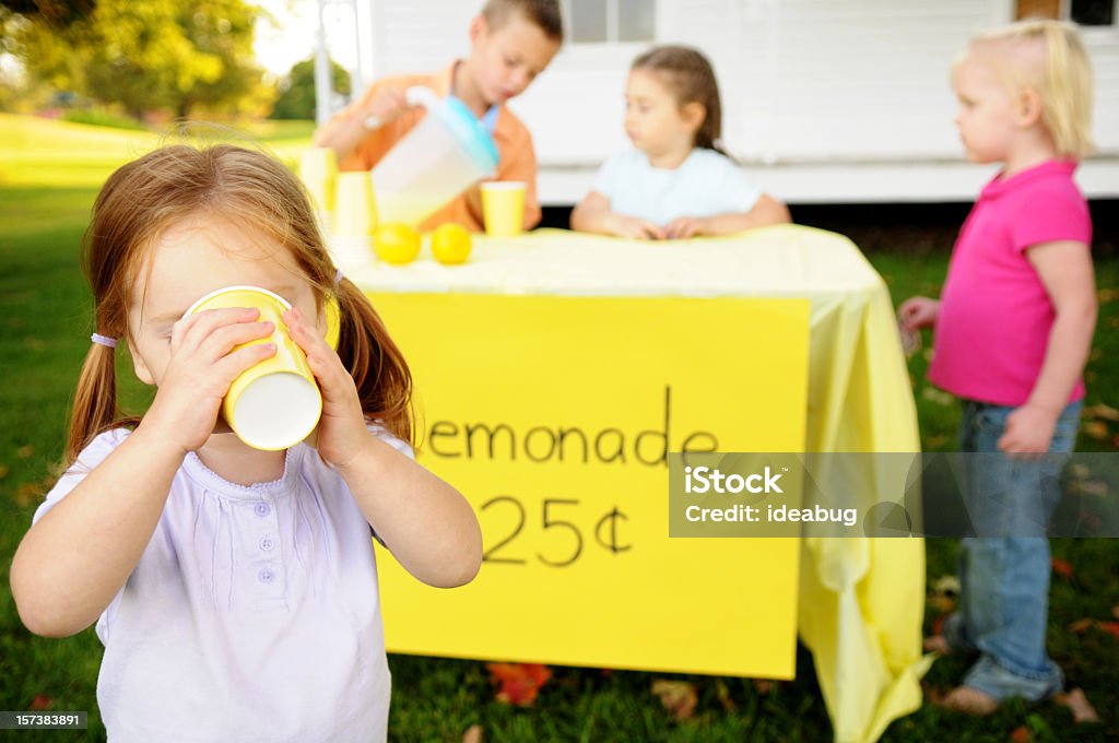 Menina tomando limonada na frente de um pé - Foto de stock de Barraca de Limonada royalty-free