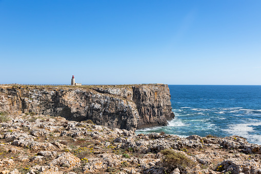 Historical Farol de Sagres (Lighthouse of Ponta de Sagres) on a beautiful sunny day located on a high cliff, Algarve, Portugal
