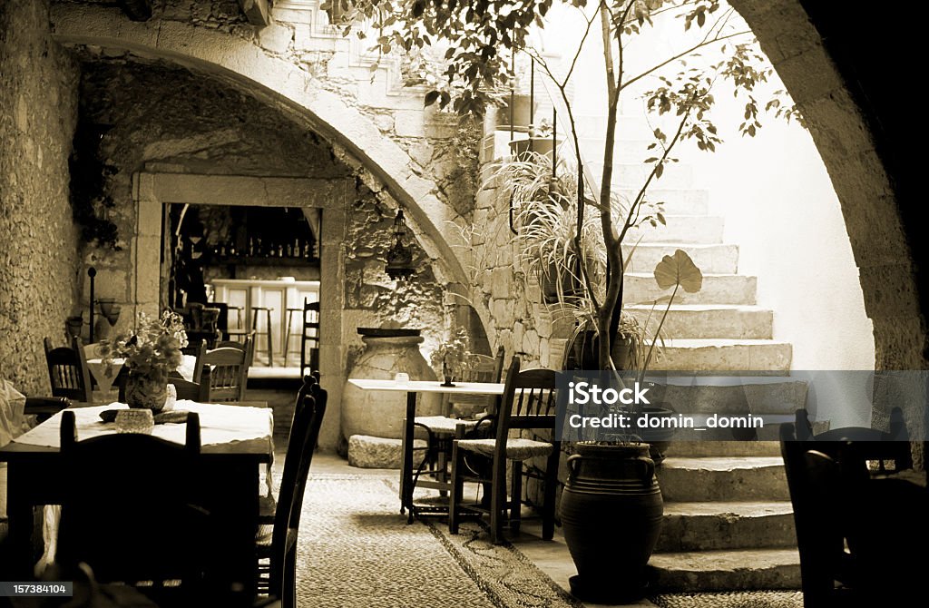 Romántico restaurante interior en Grecia, mesas de madera, sillas, sepia - Foto de stock de Grecia - Europa del sur libre de derechos