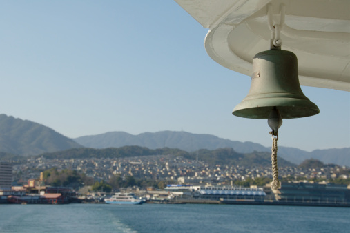 Picture of a golden copper bell hanging on the wall of church area