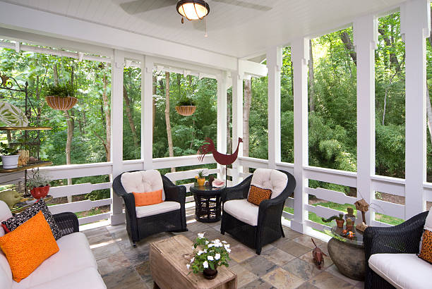 Peaceful enclosed back deck/porch with furniture This enclosed screened back deck with relaxing furniture feels you peace and calmness as you view the luscious scenery.  confined space stock pictures, royalty-free photos & images