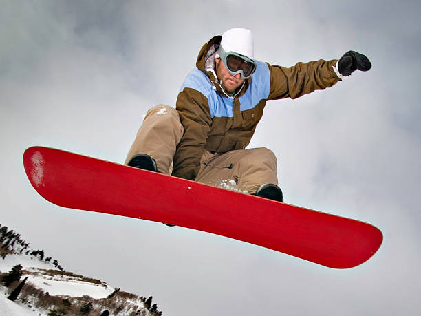 snowboarder pulando e comer a bordo - snowboarding snowboard teenager red - fotografias e filmes do acervo