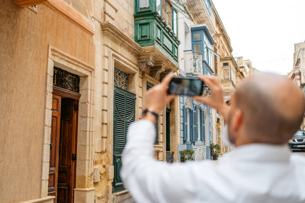 istock Young Man Taking Pictures Using His Smart Phone In Cospicua In Malta 1573846395