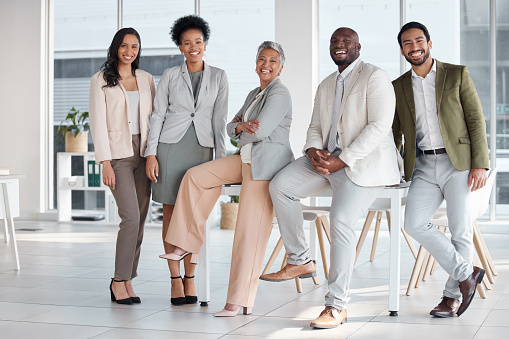 Team, diversity and portrait of business people in the office posing together after a meeting. Collaboration, staff and multiracial group of colleagues or friends standing in the modern workplace.