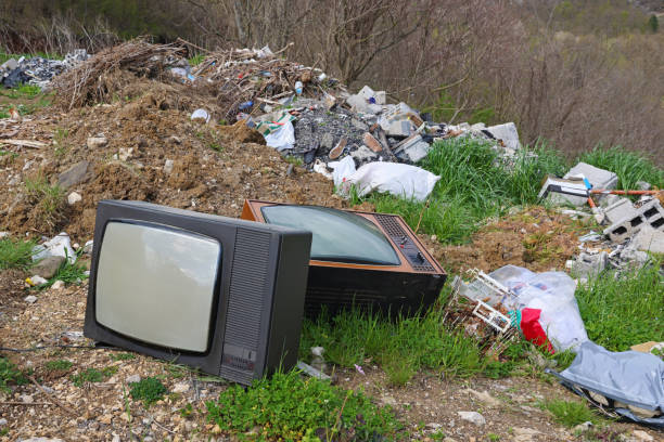 istock Old retro television set at a junkyard. Broken TV with garbage dump, environmental pollution 1573850464