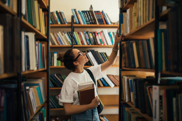 istock A student stuying and reading books in a public library. 1573866938