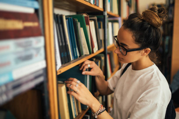 istock A student stuying and reading books in a public library. 1573866939